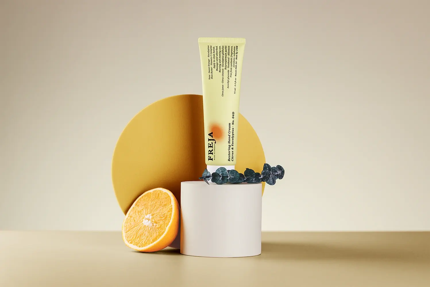 Freja toner bottle styled with a halved orange and blueberries on a warm beige backdrop