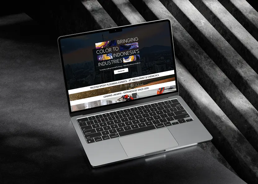 Laptop mockup of the Mella Paint website homepage, dark hero over a city skyline with Trusted Epoxy Flooring Experts copy