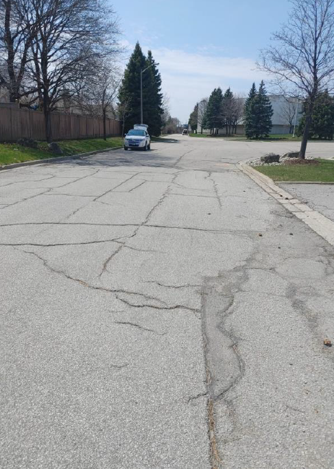 3-Ground-level photo of the cracked, deteriorated asphalt before reconstruction