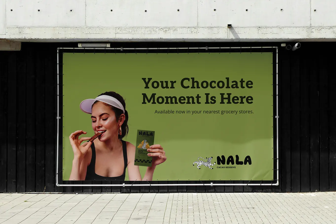 Banner ad mockup attached to a black wall reading Your Chocolate Moment Is Here