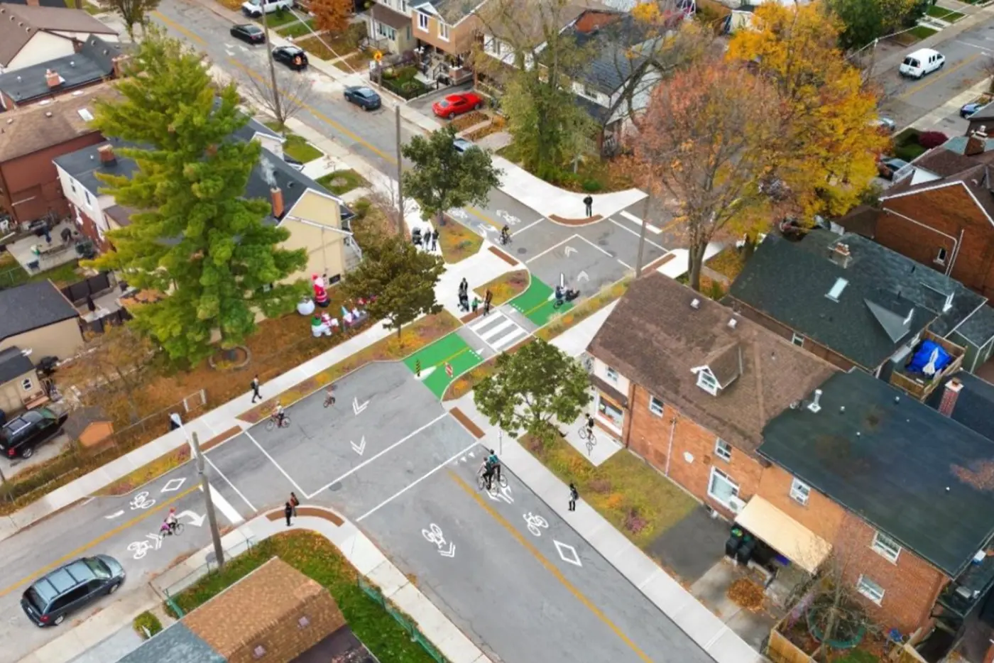 Rendered visualization of the redesigned streetscape with a cycle track, marked crosswalk, and added greenery